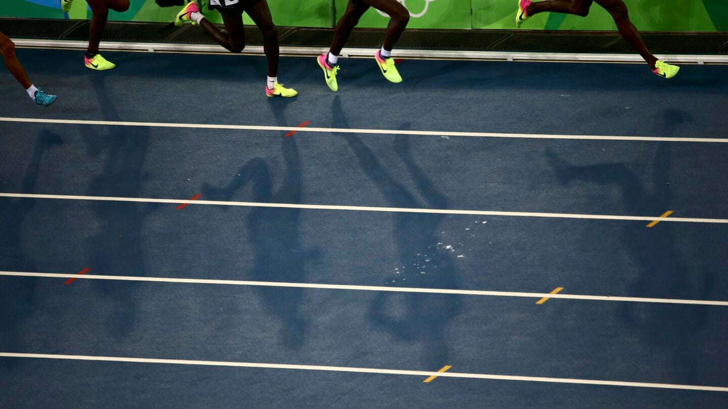 Varios atletas corren en una pista de atletismo
