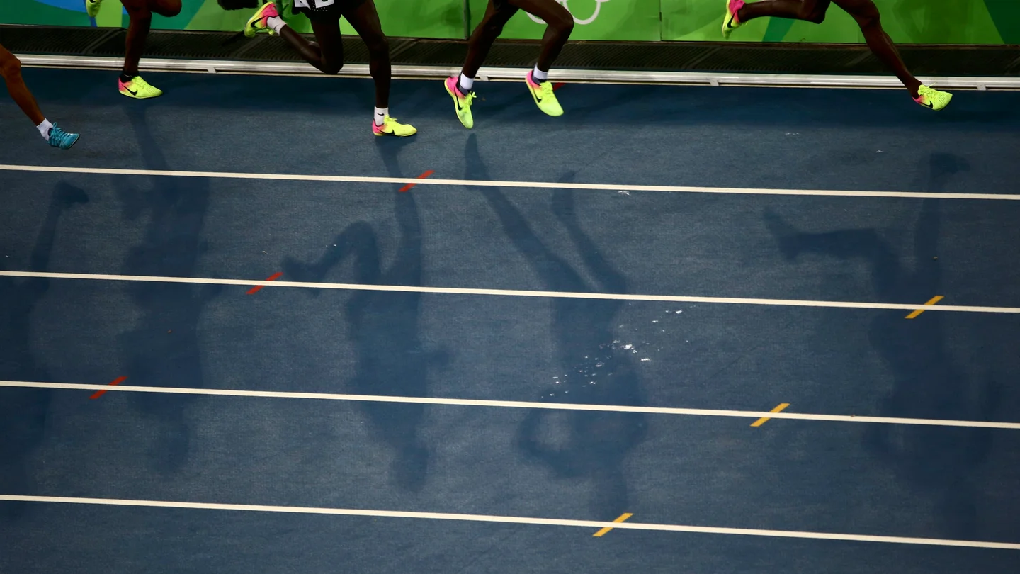 Varios atletas corren en una pista de atletismo Varios atletas corren en una pista de atletismo