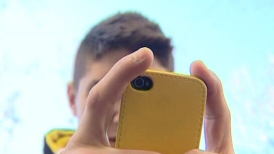 Un joven usando su tel&eacute;fono m&oacute;vil