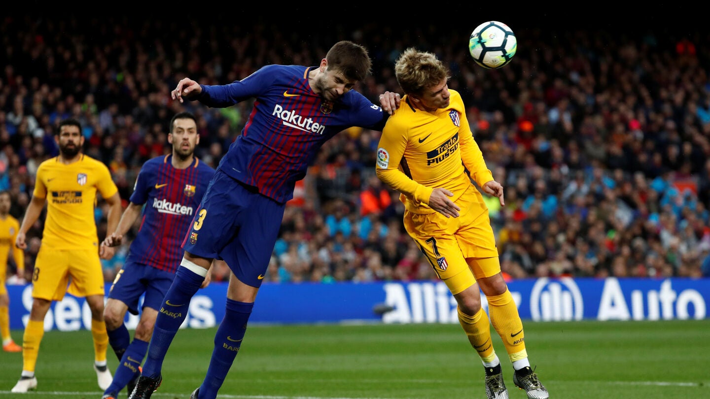 Piqu&eacute; y Griezmann se disputan el bal&oacute;n por alto