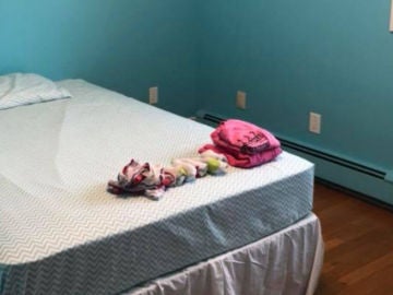 La habitación de la hija de Amanda Mitchel con la cama de la pequeña y la ropa contra el acoso La habitación de la hija de Amanda Mitchel con la cama de la pequeña y la ropa contra el acoso