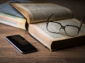 Imagen de un libro, unas gafas y un teléfono móvil