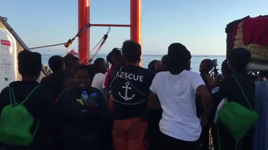 Sonrisas, cánticos y saludos de los migrantes de la flota del Aquarius al llegar al puerto de Valencia