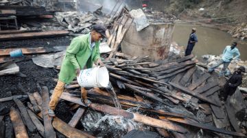 Miembros de los servicios de rescate trabajan entre los escombros tras un incendio en el mercado Gikomba en Nairobi