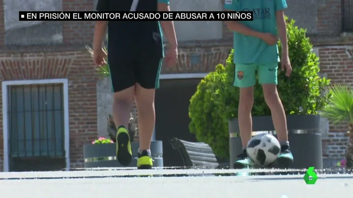 Dos niños juegan a la pelota en la calle