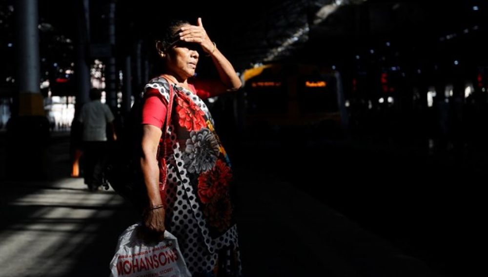 Mujer india esperando al transporte público
