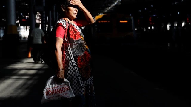 Mujer india esperando al transporte público