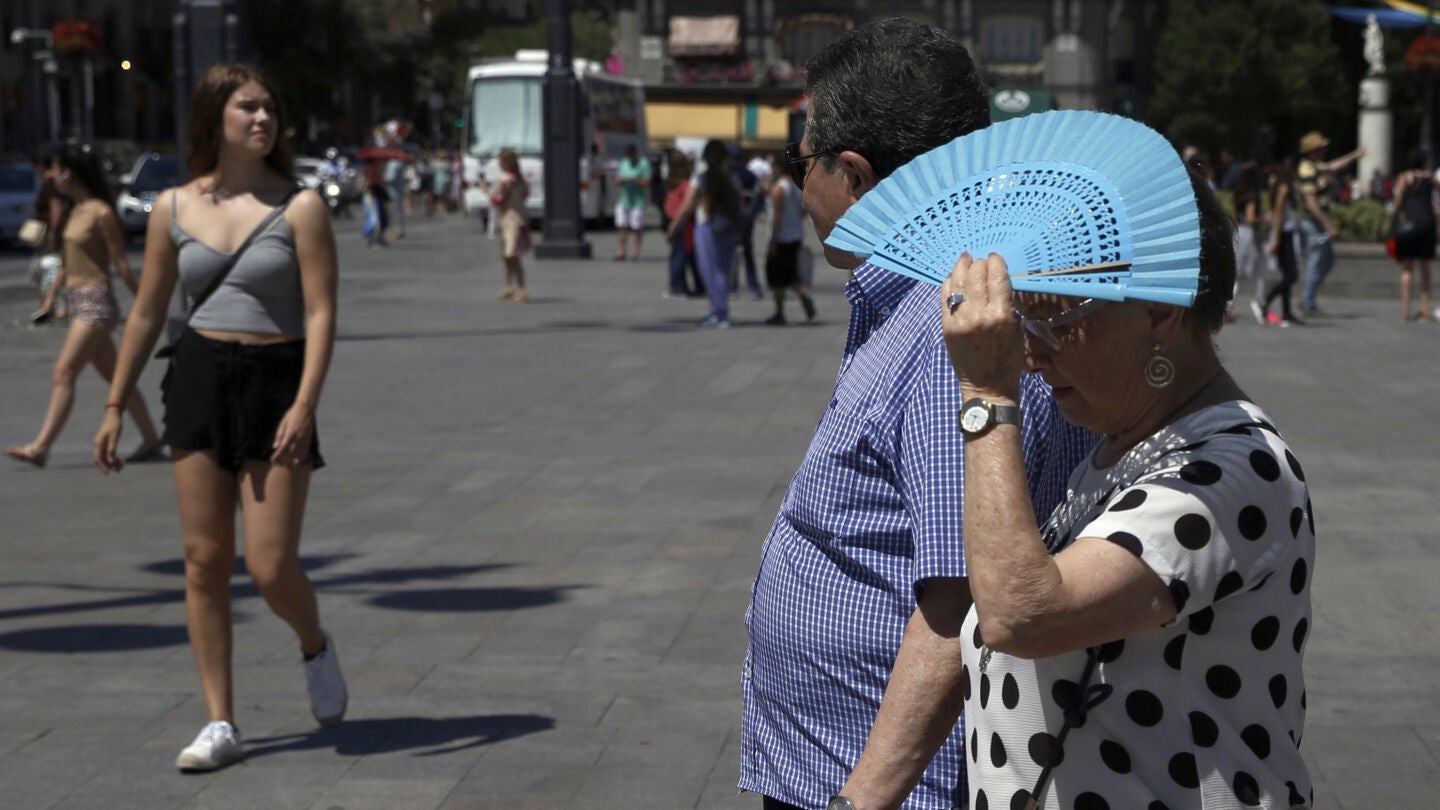 Imagen de archivo de una mujer tap&aacute;ndose con el abanico por el calor