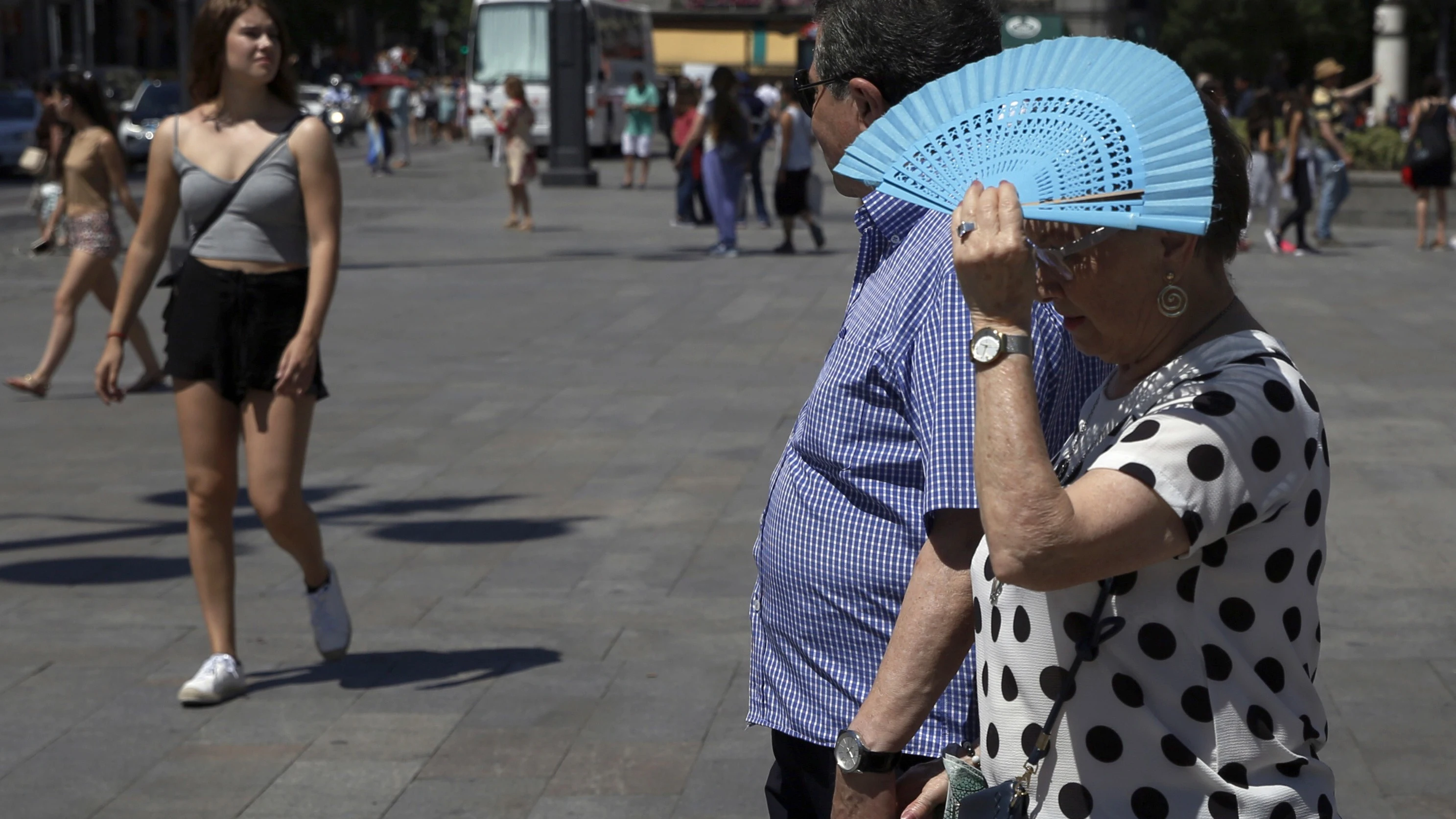 Imagen de archivo de una mujer tapándose con el abanico por el calor