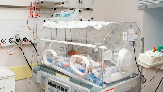 Bebé en una incubadora Bebé en una incubadora