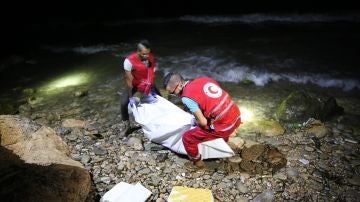 Personal de rescate de la Media Luna Roja Libia transportan el cuerpo de un inmigrante fallecido.