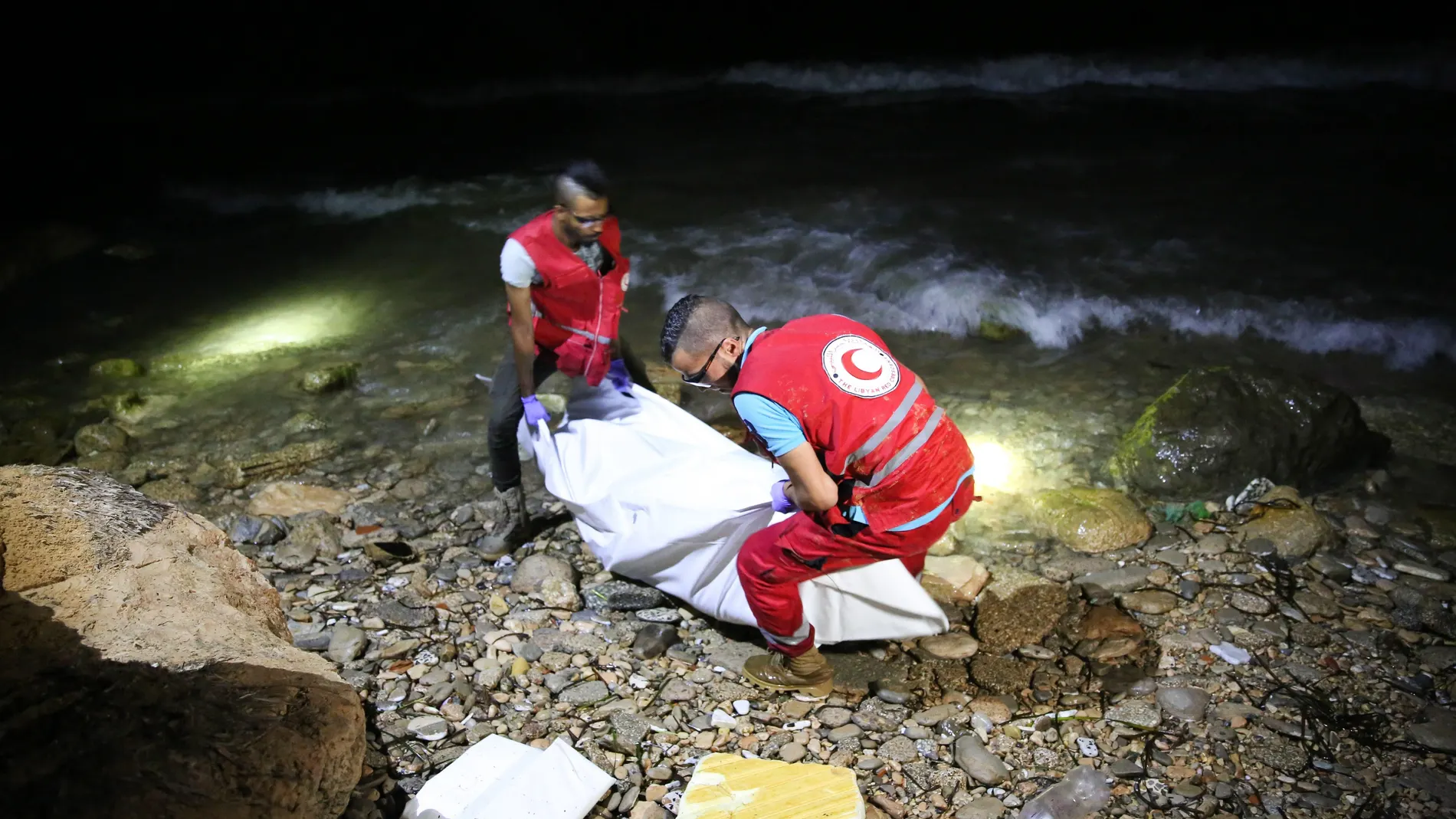 Personal de rescate de la Media Luna Roja Libia transportan el cuerpo de un inmigrante fallecido.