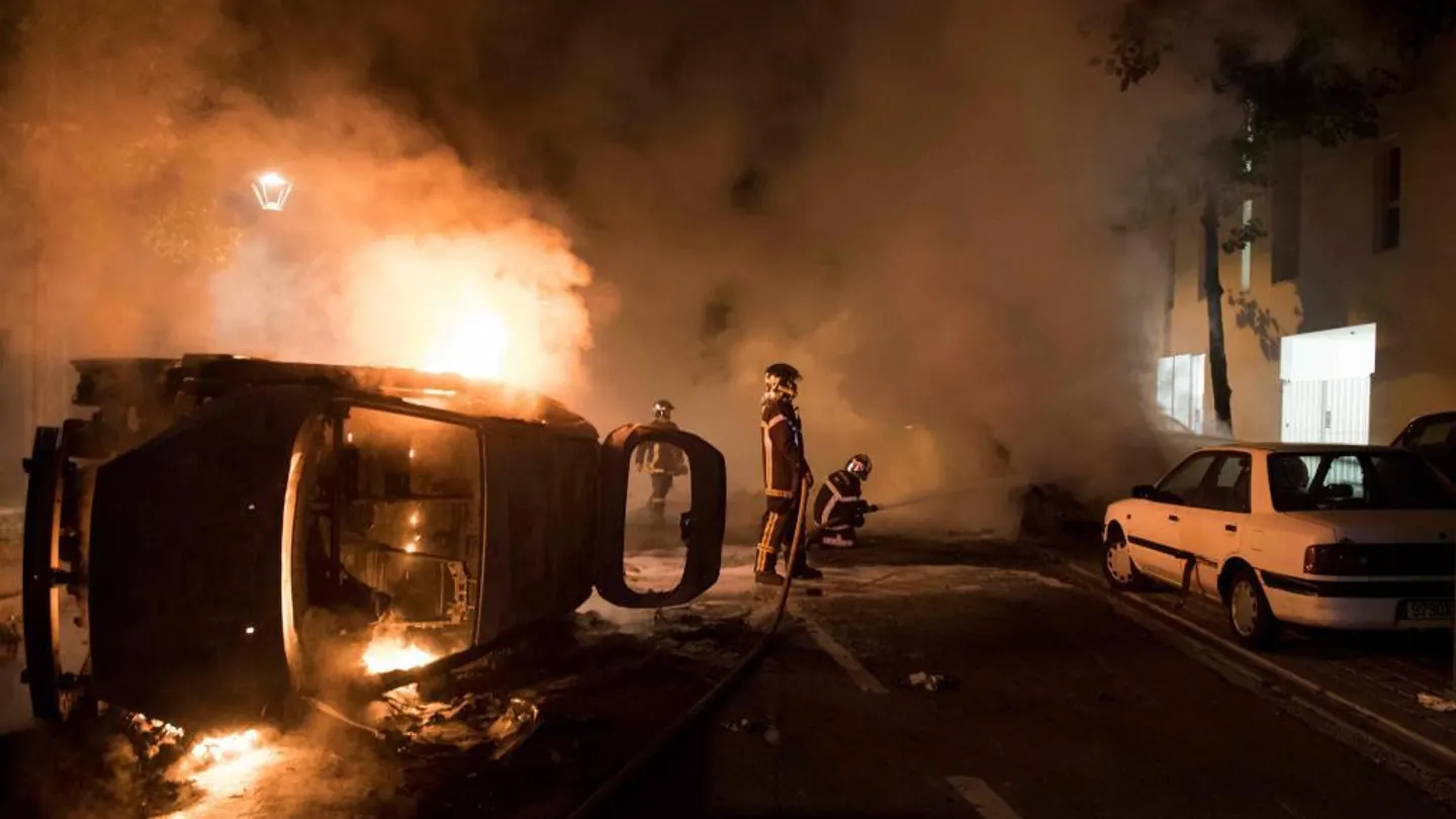 Los bomberos tratan de apagar el fuego de un coche incendiado en el barrio de Malakoff , en Nantes Los bomberos tratan de apagar el fuego de un coche incendiado en el barrio de Malakoff , en Nantes