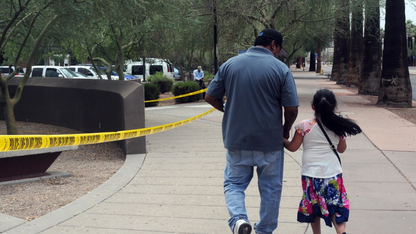 Un hombre camina junto a su hija tras salir de la Oficina de Control de Inmigraci&oacute;n y Aduanas