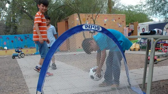 Un grupo de niños jugando fútbol en el patio del albergue Casa Alitas Un grupo de niños jugando fútbol en el patio del albergue Casa Alitas