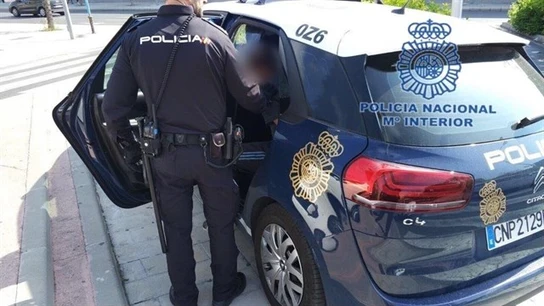 En la imagen coche de policía con un policía En la imagen coche de policía con un policía