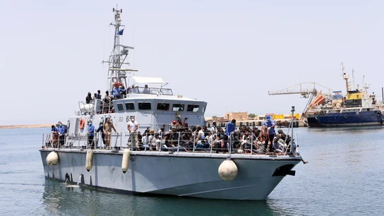 Un barco de la Armada de Libia con inmigrantes a bordo llega a una base  Un barco de la Armada de Libia con inmigrantes a bordo llega a una base