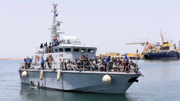 Un barco de la Armada de Libia con inmigrantes a bordo llega a una base 