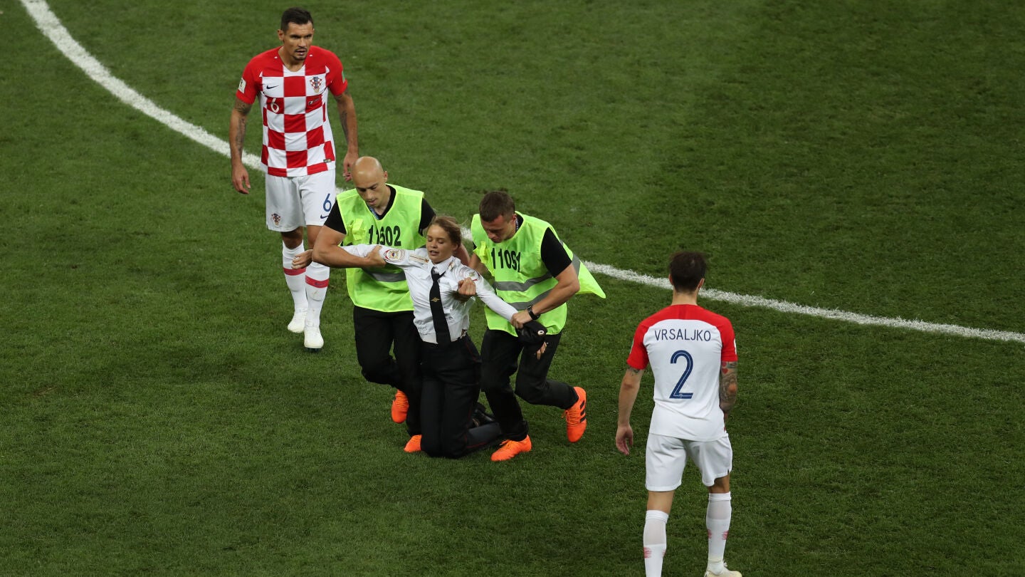 Los miembros de seguridad sacan del campo a una activista en la final del Mundial
