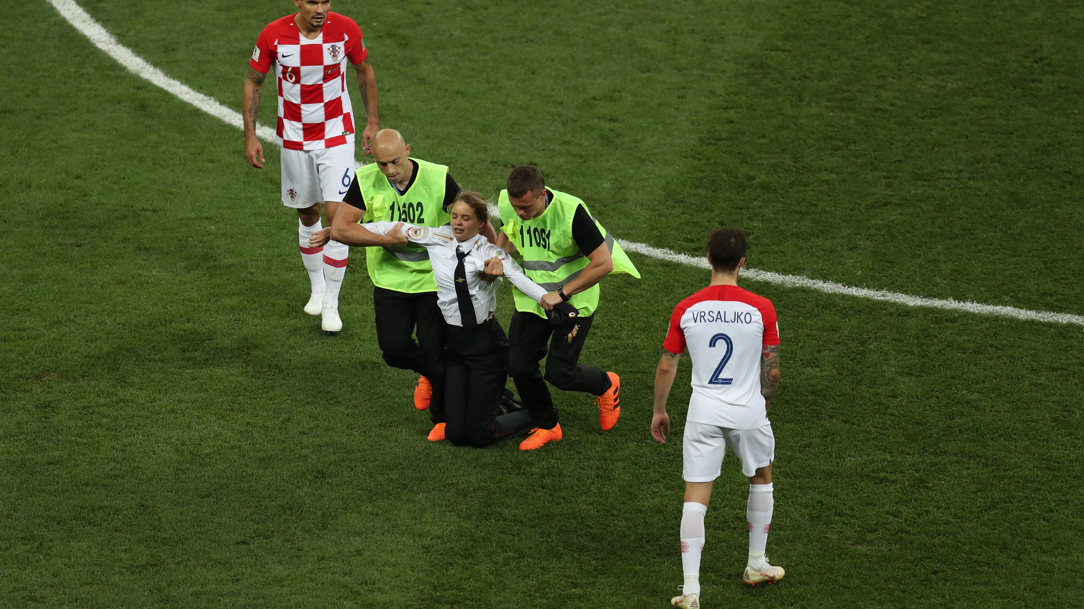 Los miembros de seguridad sacan del campo a una activista en la final del Mundial