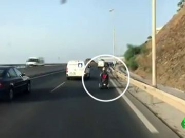 Circula con una silla de ruedas motorizada por una autovía de Málaga Circula con una silla de ruedas motorizada por una autovía de Málaga