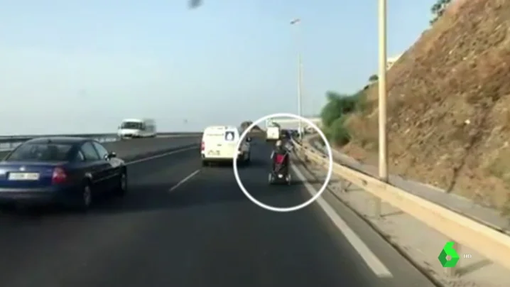 Circula con una silla de ruedas motorizada por una autovía de Málaga