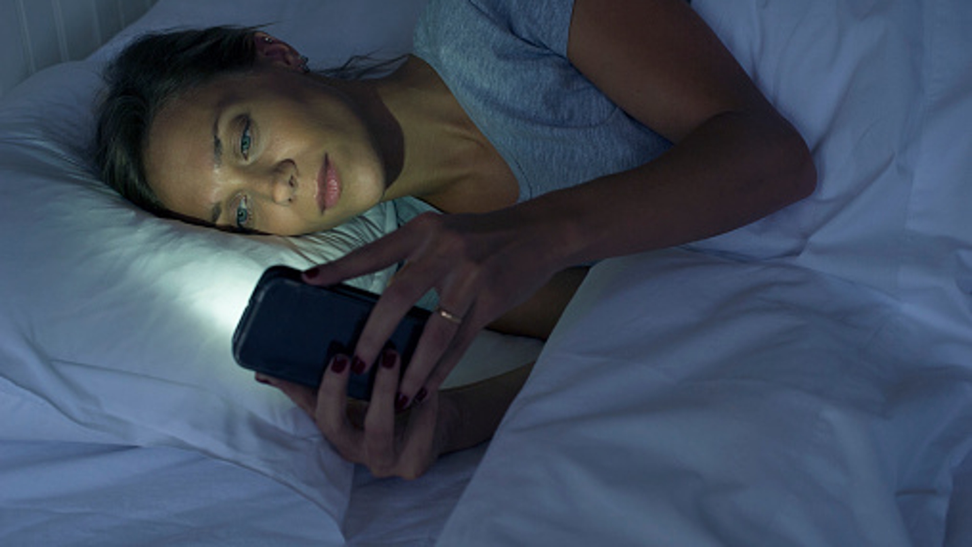 Una mujer mira el móvil antes de dormir