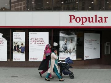 Unas mujeres pasan ante una oficina del Banco Popular. Unas mujeres pasan ante una oficina del Banco Popular.