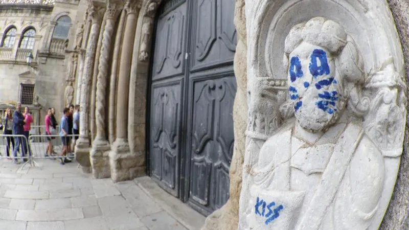 La fachada de Platerías de la catedral de Santiago de Compostela ha aparecido esta mañana con un grafiti en una de sus figuras, que aparece pintada emulando a uno de los miembros de Kiss