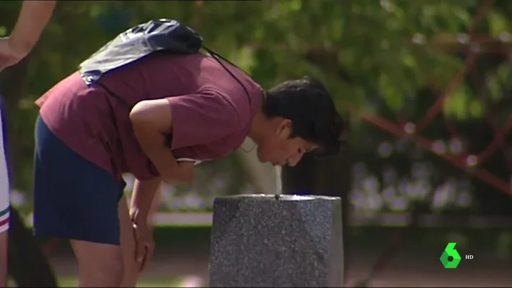 Una persona bebiendo agua de una fuente 