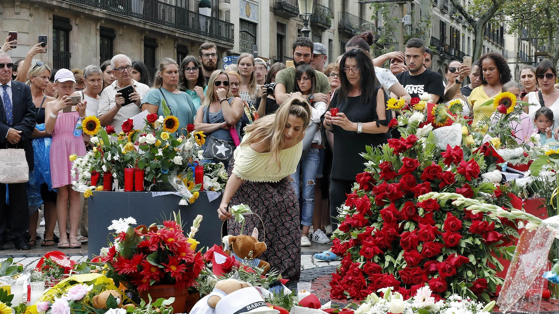 Grupo de personas depositan flores esta tarde en el mosaico de Miró en Las Ramblas