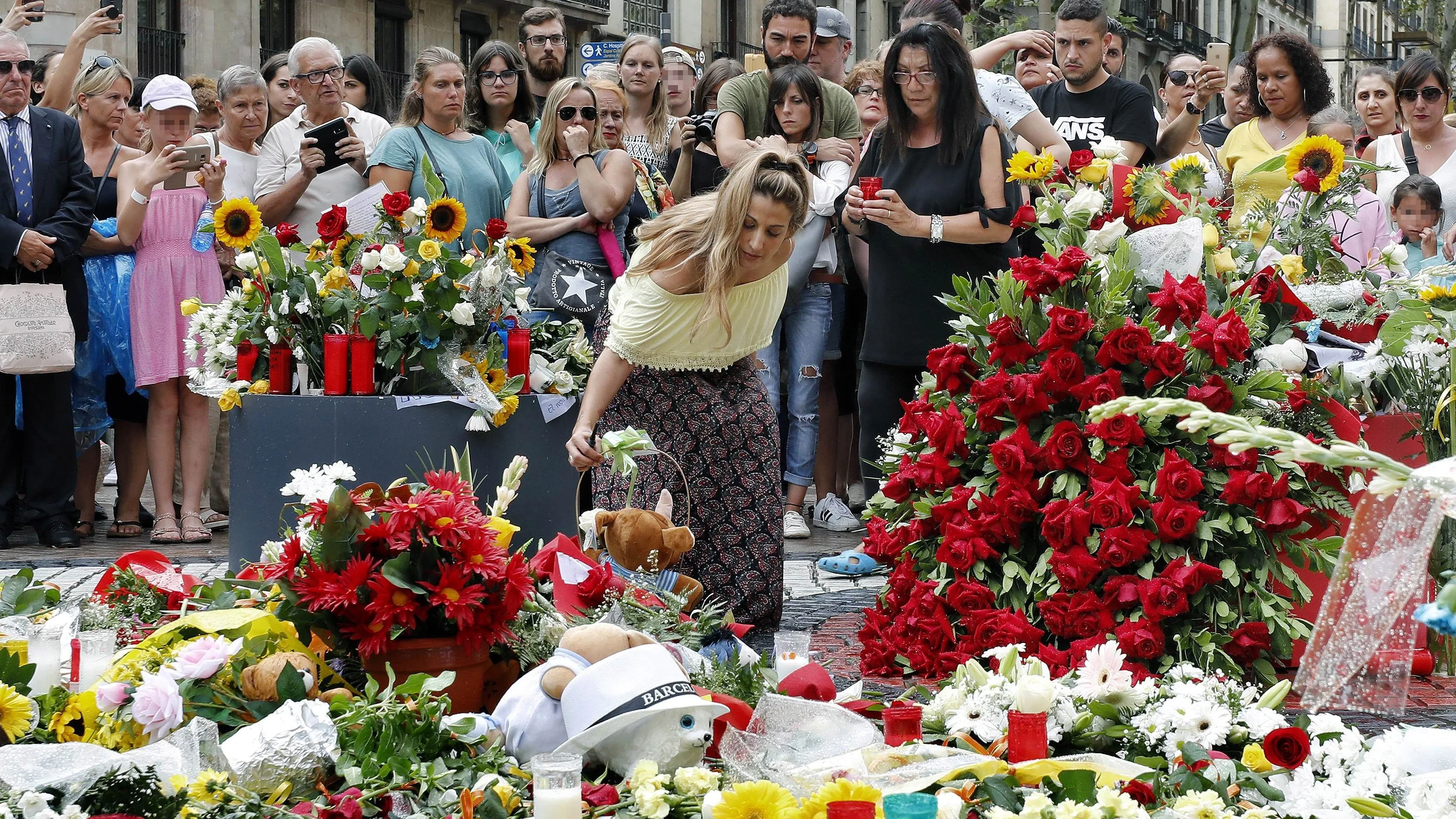 Grupo de personas depositan flores esta tarde en el mosaico de Miró en Las Ramblas