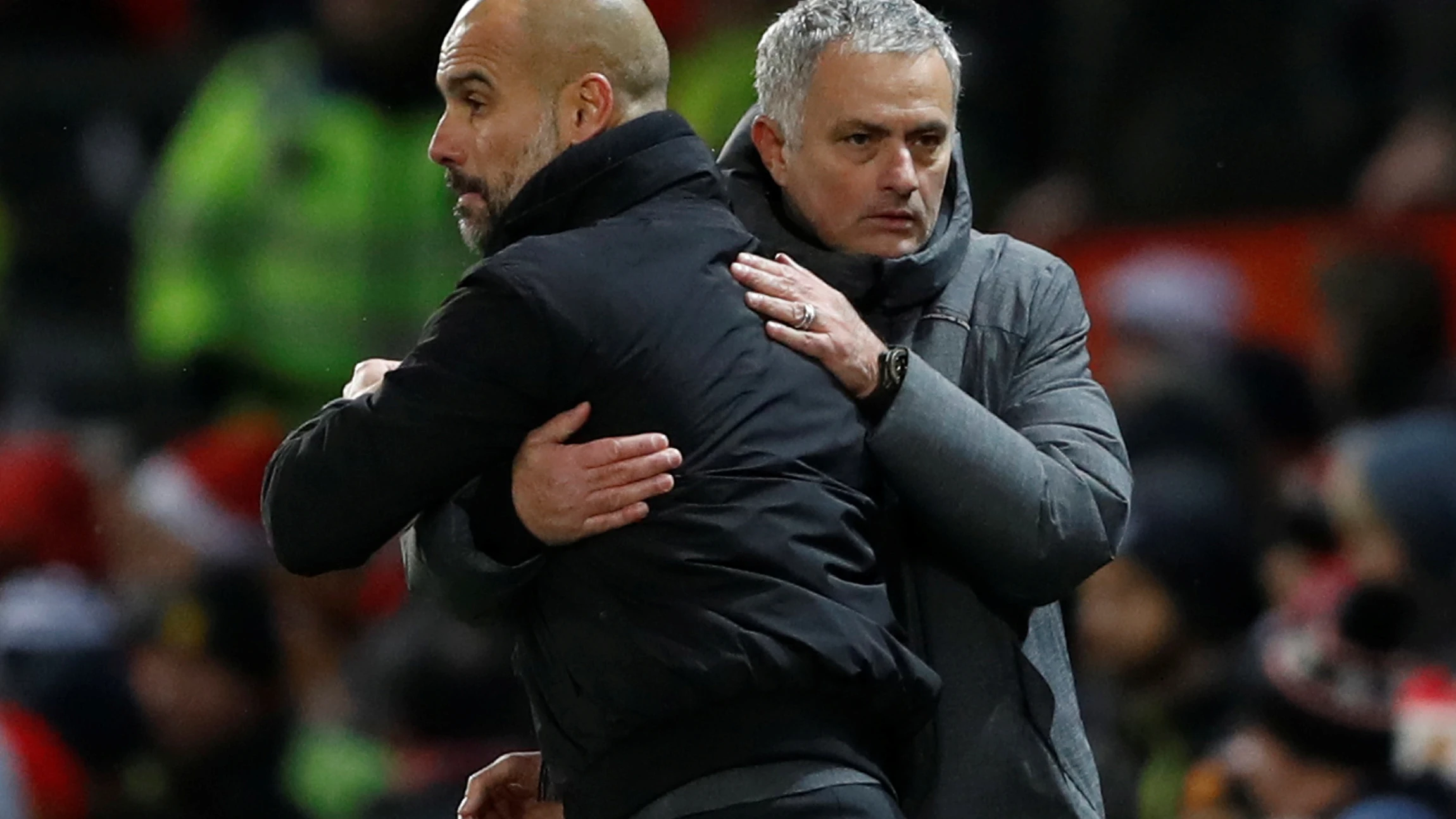 Guardiola y Mourinho se saludan durante un derbi de Manchester