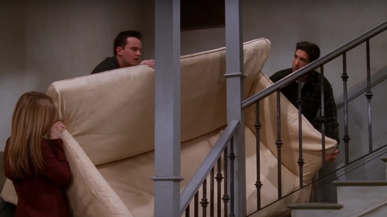 Escena de 'Friends' en la que intentan subir un sofá