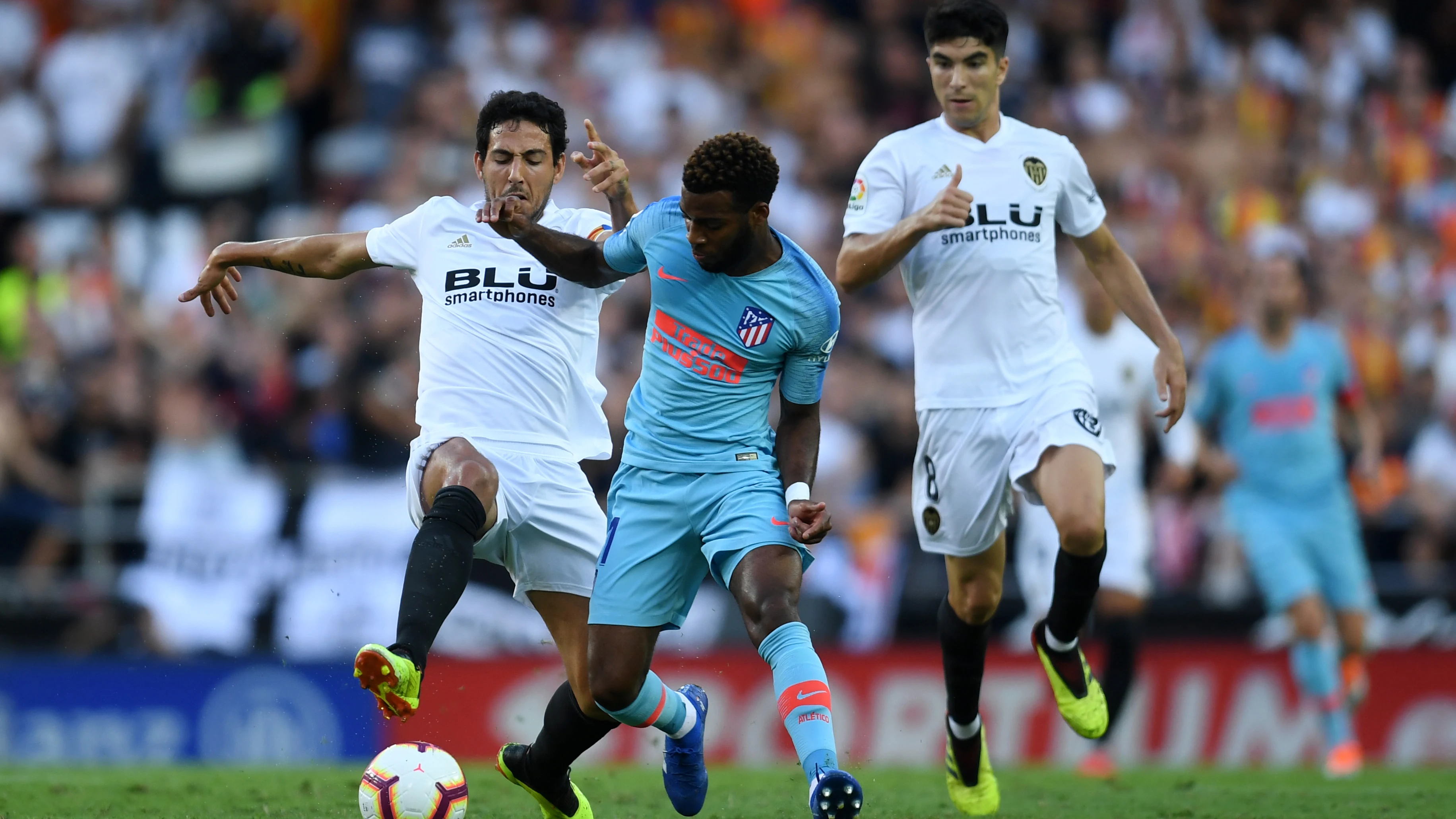 Lemar conduce el balón ante la presión de Parejo y Carlos Soler