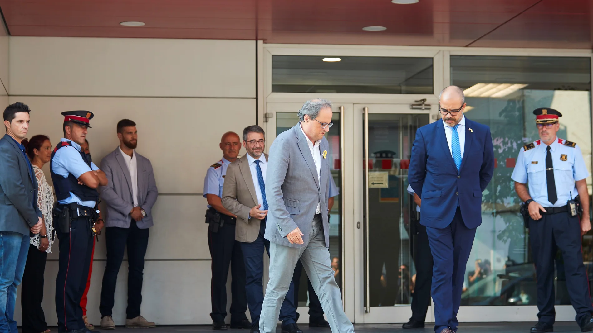 El presidente de la Generalitat, Quim Torra y el conseller de Interior Miquel Buch acompañados de mandos policiales salen de la comisaria de los Mossos d'Esquadra en Cornellà