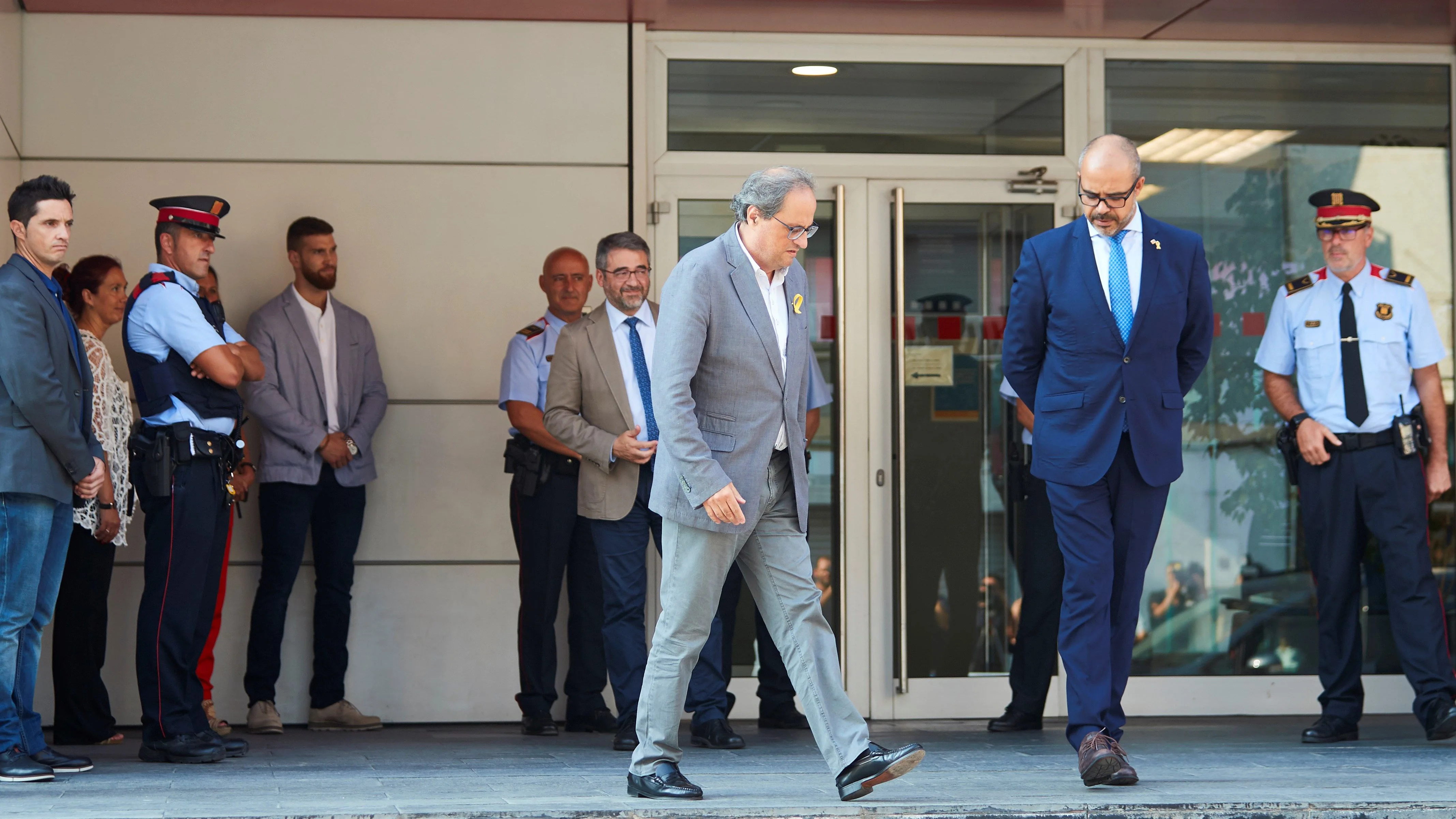 El presidente de la Generalitat, Quim Torra y el conseller de Interior Miquel Buch acompañados de mandos policiales salen de la comisaria de los Mossos d'Esquadra en Cornellà