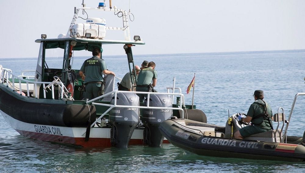 Agentes del Servicio Especial de Actividades Subacuáticas de la Guardia Civil tras recuperar el cadáver de un joven en una playa de Salobreña 