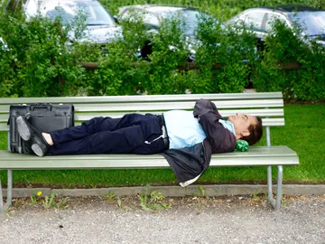 Hombre tumbado en un banco Hombre tumbado en un banco