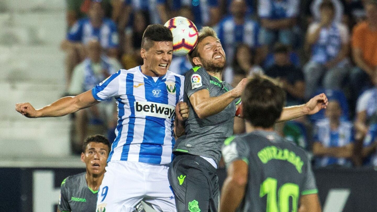 Guido Carrillo e Illarramendi disputan el bal&oacute;n a&eacute;reo