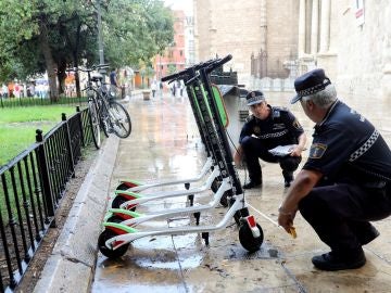 Unos agentes de la Policía Local trabajan en la retirada de los patinetes Unos agentes de la Policía Local trabajan en la retirada de los patinetes
