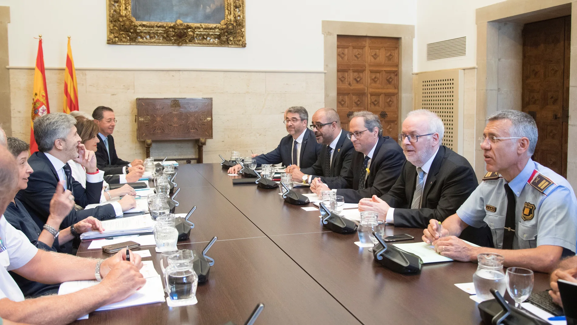 El presidente de la Generalitat , Quim Torra (3d), junto al conseller de Interior Miquel Buch (2i) en la parte derecha de la mesa junto al ministro de Interior, Fernando Grande-Marlaska