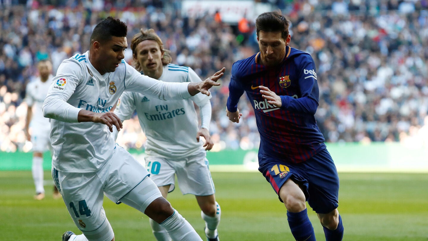 Casemiro intenta arrebatar el bal&oacute;n a Messi