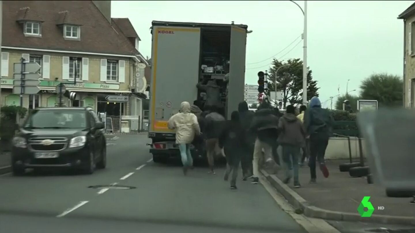 Decenas de migrantes tratan de subir a un cami&oacute;n para alcanzar Reino Unido
