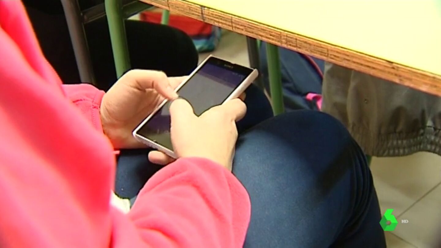 Un alumno usando el m&oacute;vil en clase