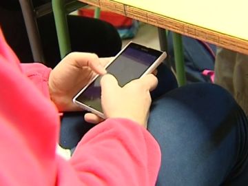 Un alumno usando el móvil en clase Un alumno usando el móvil en clase