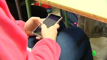 Un alumno usando el móvil en clase