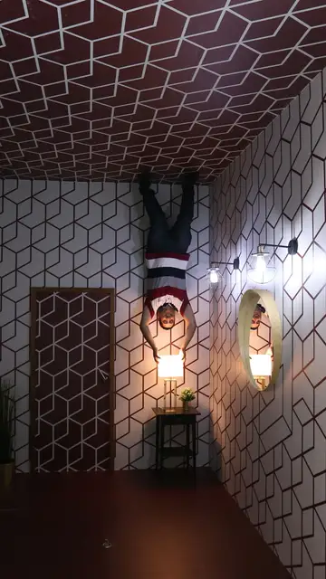 Un visitante del museo posa para una foto que da la ilusión de que está boca abajo Un visitante del museo posa para una foto que da la ilusión de que está boca abajo