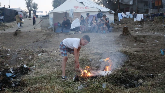 Un niño hace un fuego en el campamento de refugiados de Moria, en la isla de Lesbos (Grecia) Un niño hace un fuego en el campamento de refugiados de Moria, en la isla de Lesbos (Grecia)