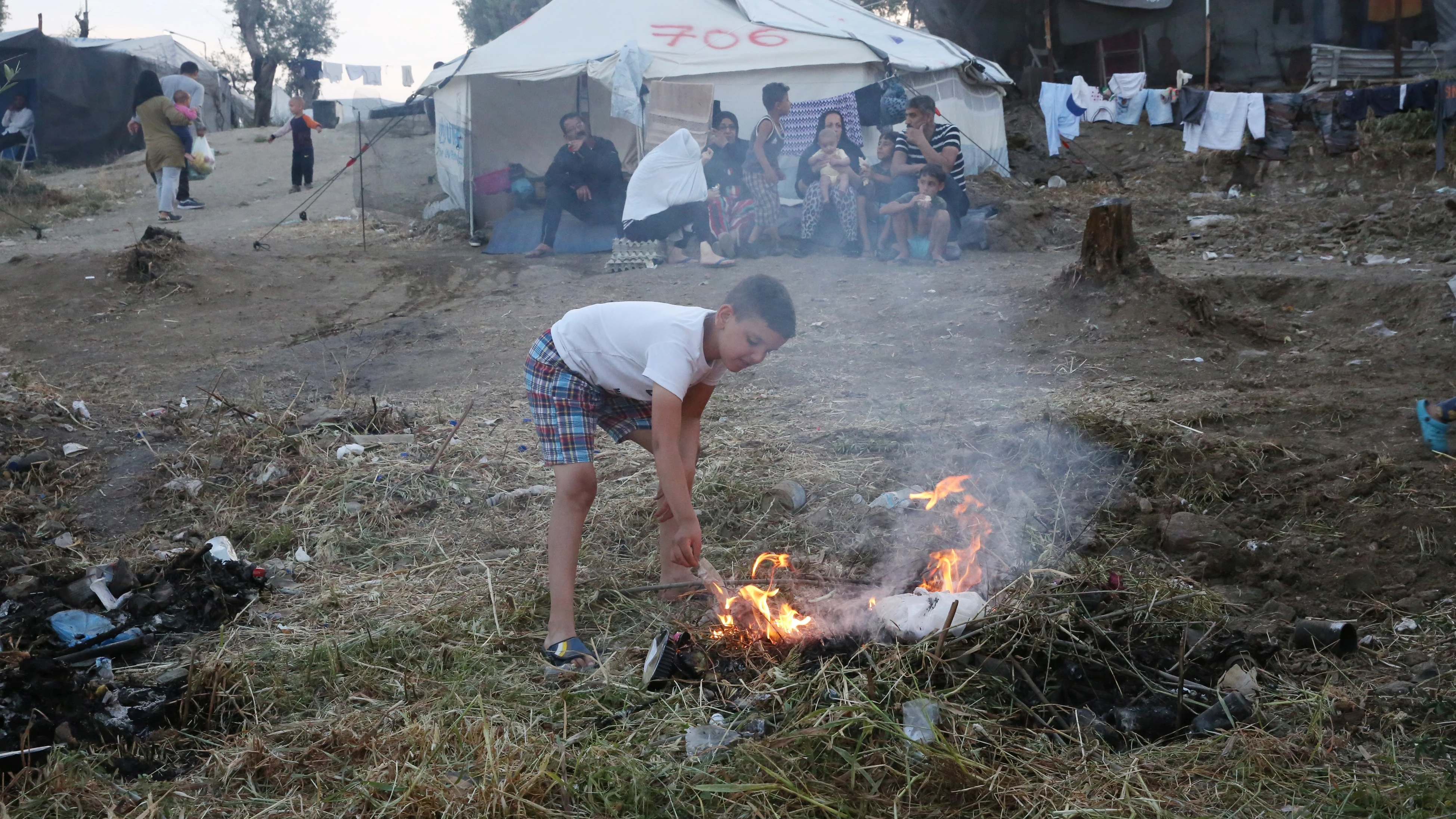 Un niño hace un fuego en el campamento de refugiados de Moria, en la isla de Lesbos (Grecia)